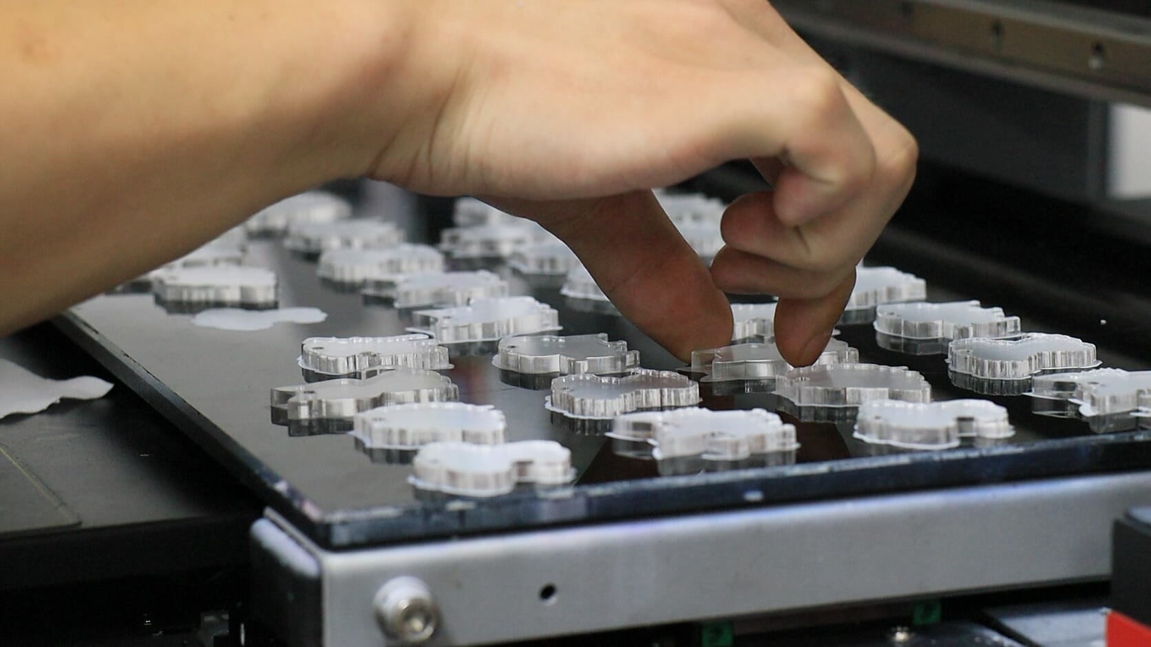 placing the acrylic key chain pieces on uv printer bed_